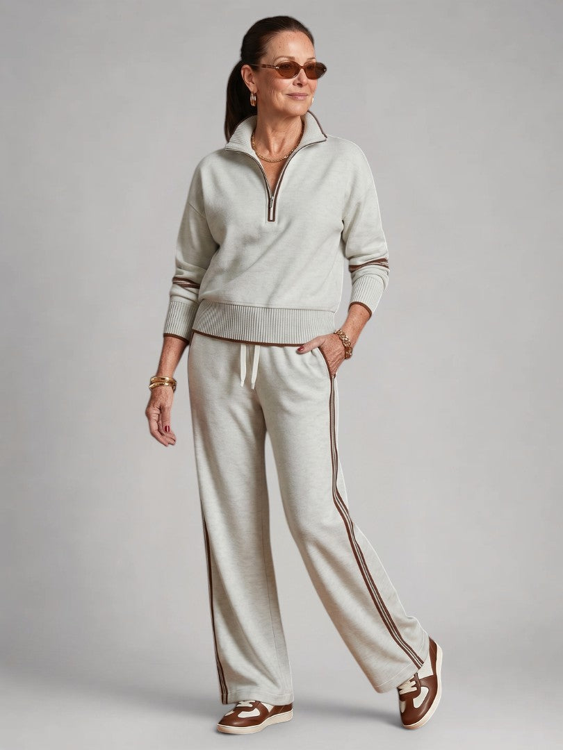 Femme portant un ensemble deux pièces en maille avec haut à col zippé et pantalon large, coloris blanc