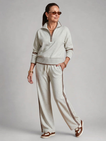Femme portant un ensemble deux pièces en maille avec haut à col zippé et pantalon large, coloris blanc