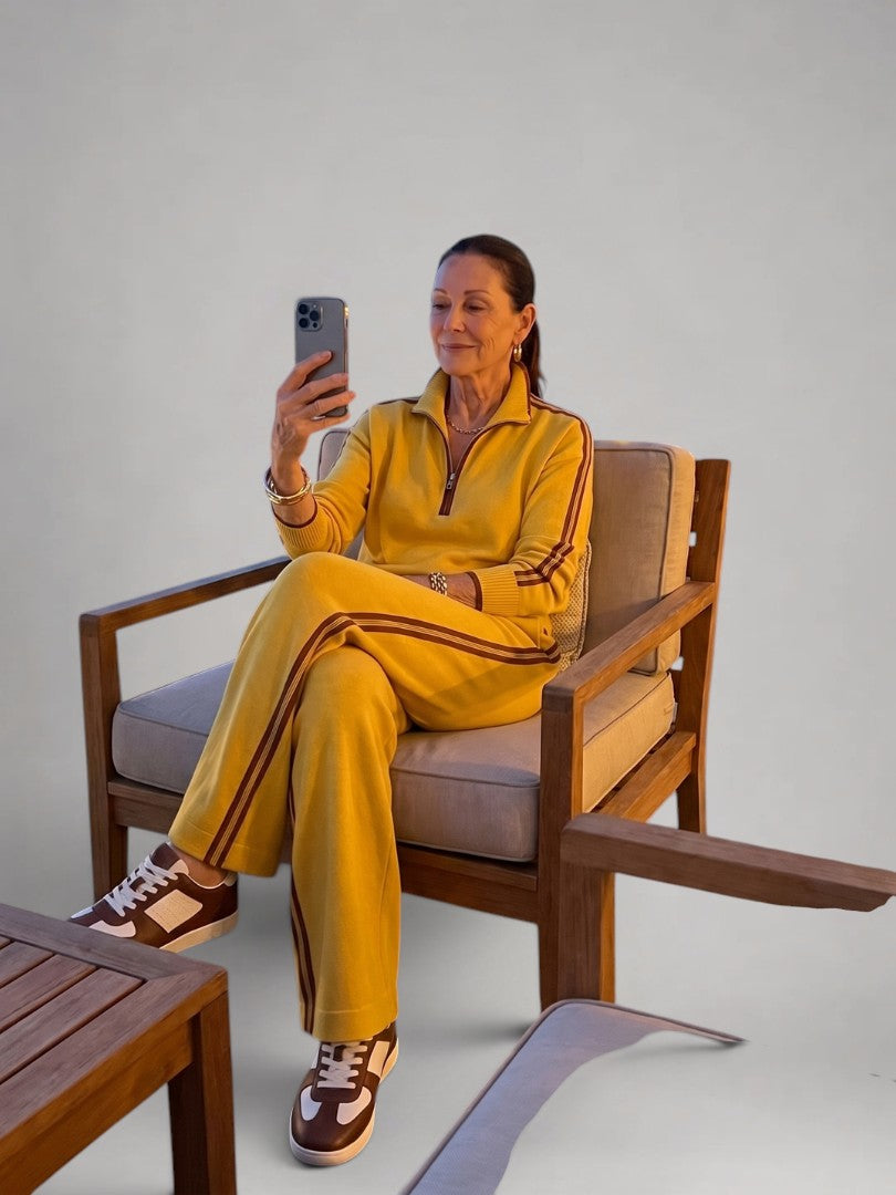 Femme portant un ensemble deux pièces en maille avec haut à col zippé et pantalon large, coloris jaune