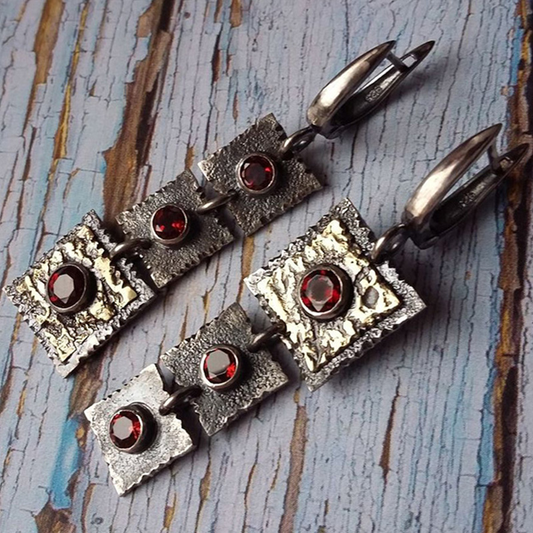 Rayure Rouge | Boucles d'oreilles argentées avec pierres rouges et zones dorées – Vue 01