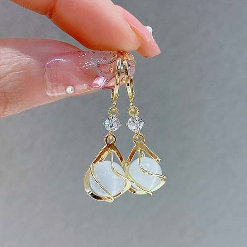 Éclat Lumineux | Boucles d'oreilles dorées avec détail blanc aux reflets opalins – Vue 01