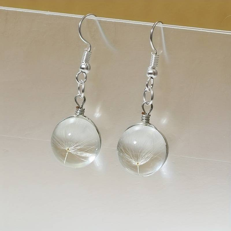 Perle Duvet | Boucles d'oreilles avec aigrettes de pissenlit dans une sphère transparente – Vue 01