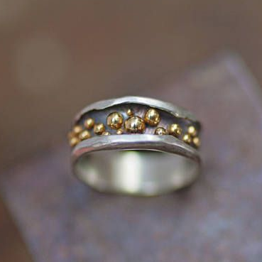 Bague argentée avec une rangée de petites perles dorées