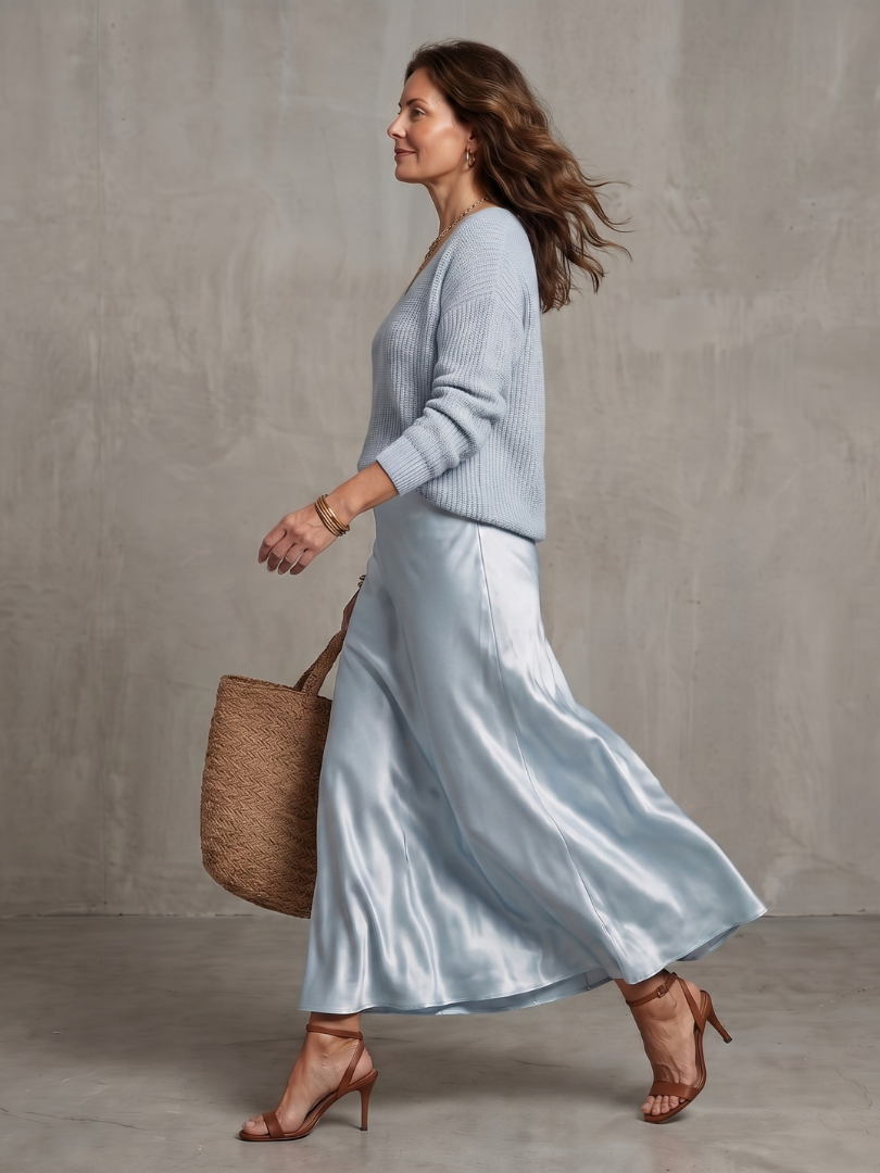 Femme portant un ensemble deux pièces avec pull en maille col V et jupe en satin, coloris bleu clair